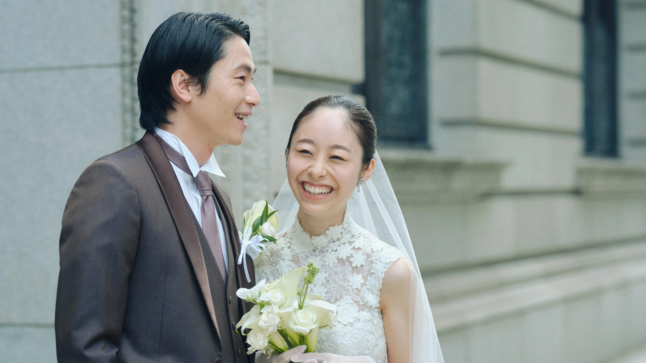 明治生命館の前で晴れやかな笑顔の新郎新婦